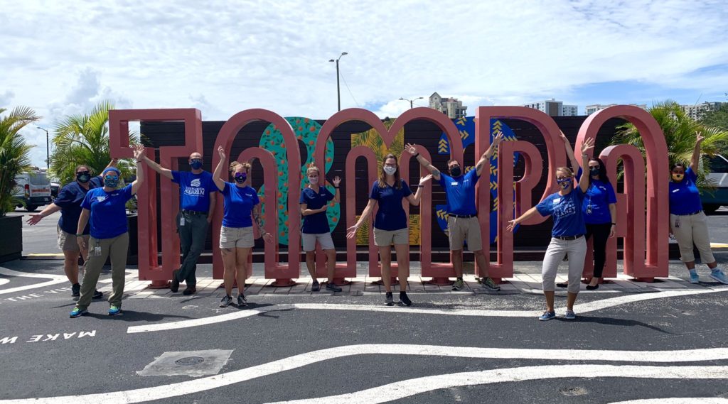 aquarium employees in front of tampa sign
