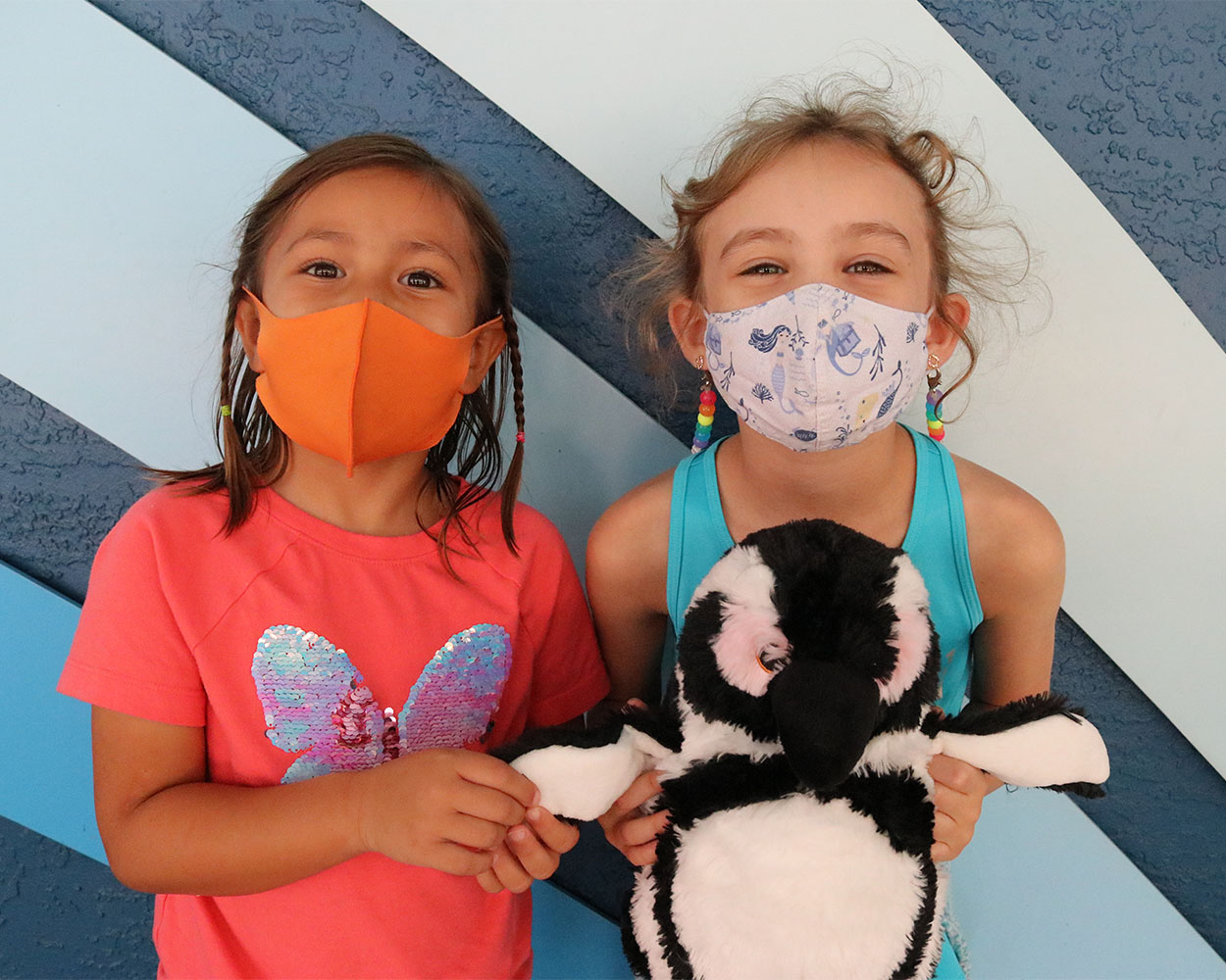 two_little_girls_holding_penguin_stuffy