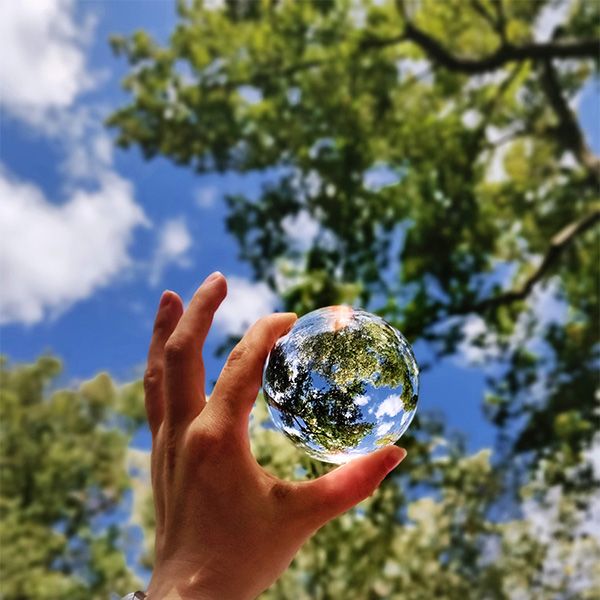 hand holding crystal ball at the sky_600x600