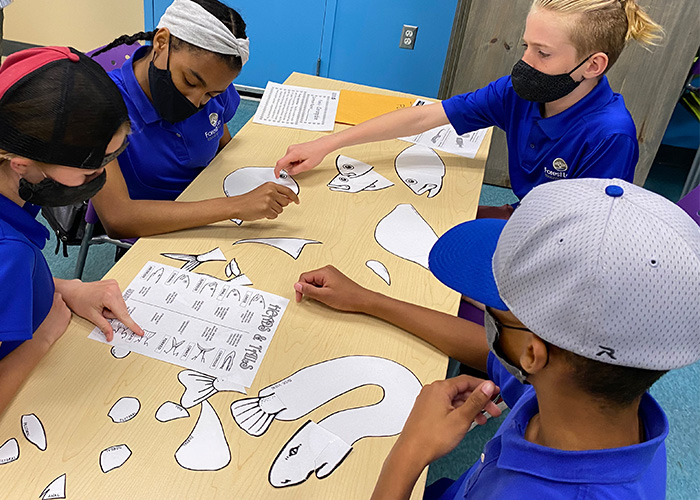 kids_at_classroom_table_aquarium_activity