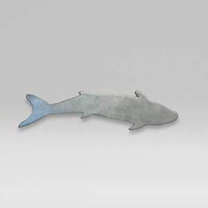 Metal sculpture of a small size fish on a gray background