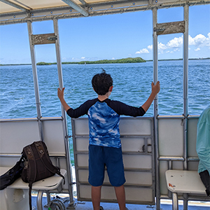 boy on boat looking at the water