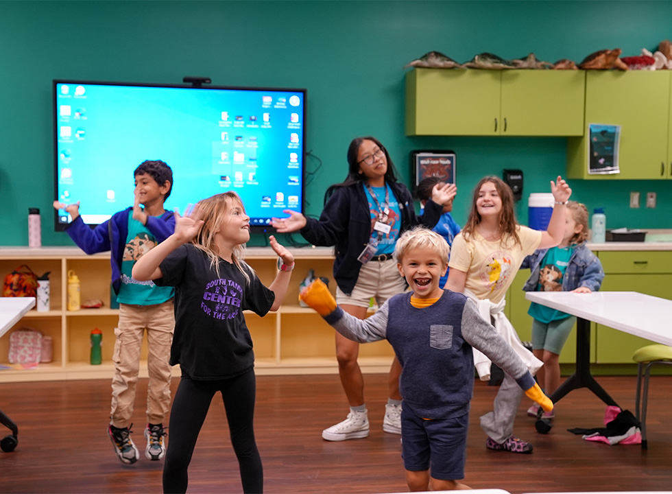 group of kids dancing with a camp staffer