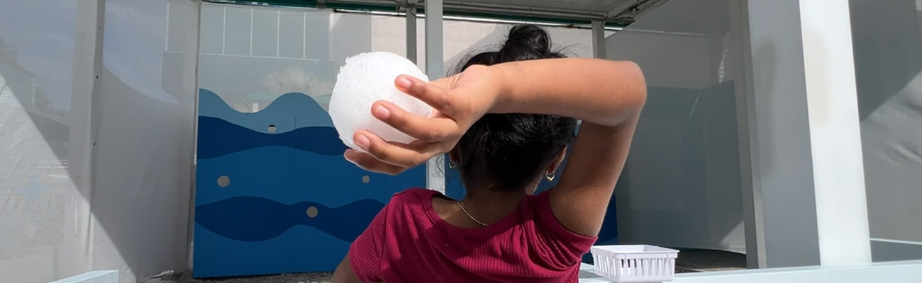 little girl with snowball in her hand, arm pulled back ready to toss the snowball