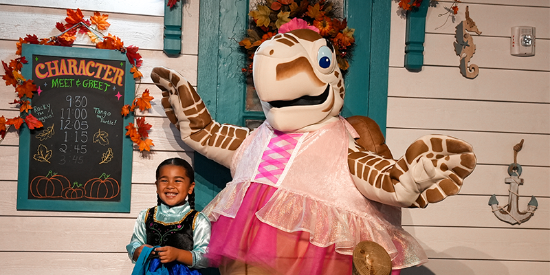 Tango the turtle with little girl dressed in her halloween costume at The Florida Aquarium