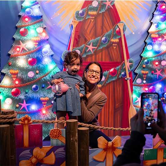 Mother and daughter taking photos at Yuletides at the Florida Aquarium
