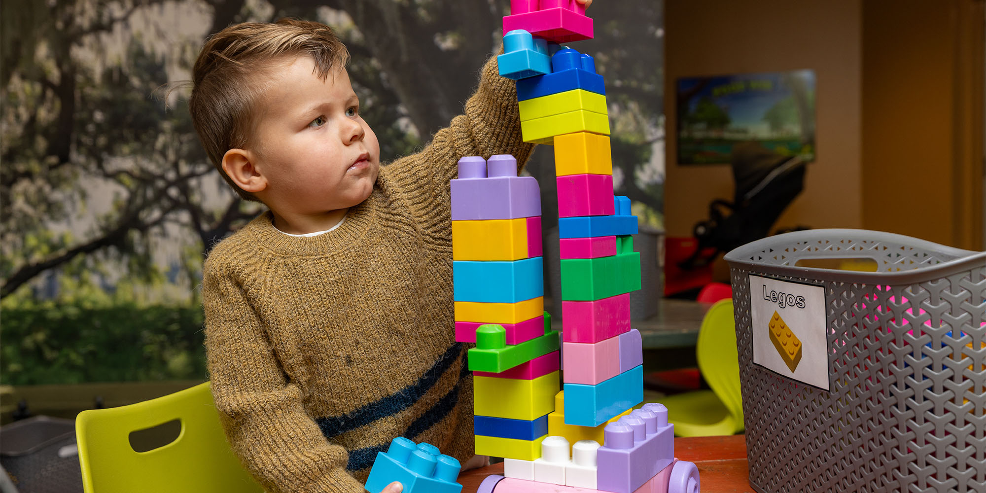 AquaTots toddler boy building a tower of blocks