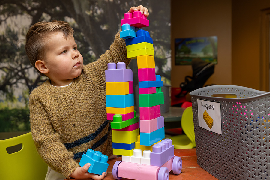 AquaTots toddler boy building a tower of blocks