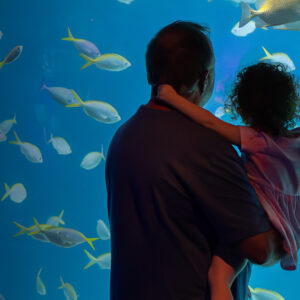 Father holding daughter in front of Heart of the Sea habitat at The Florida Aquarium