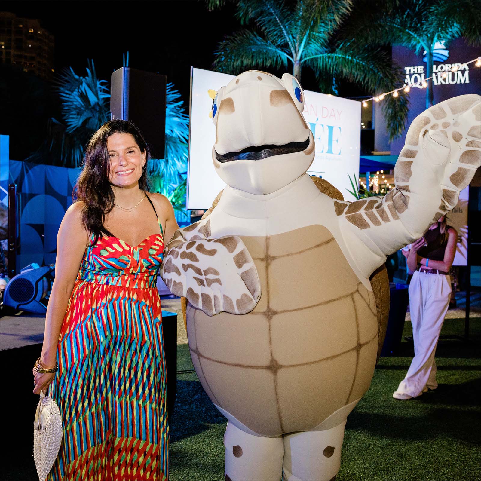 Female guest posing with loggerhead turtle costume character named Tango at the World Ocean Day Soiree benefitting The Florida Aquarium